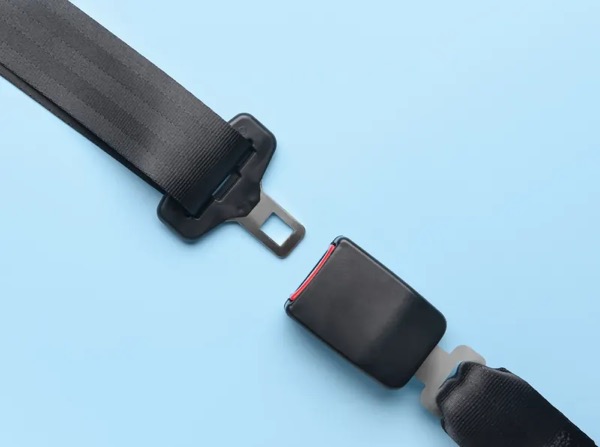 Seat belt webbing with latch plate separated from the buckle receiver, shown against a plain background