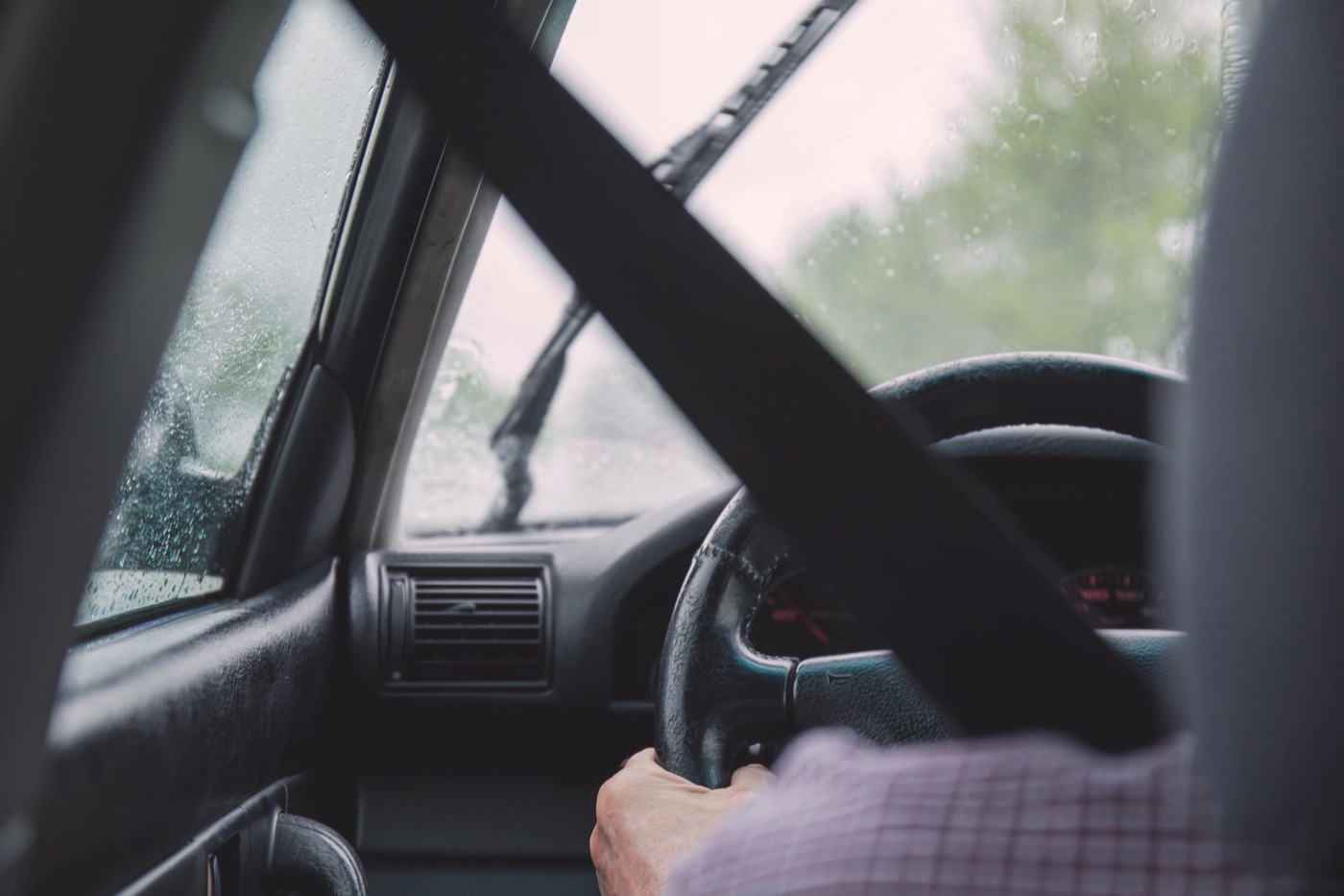 Driver at the wheel in wet weather with the seat belt worn across the shoulder